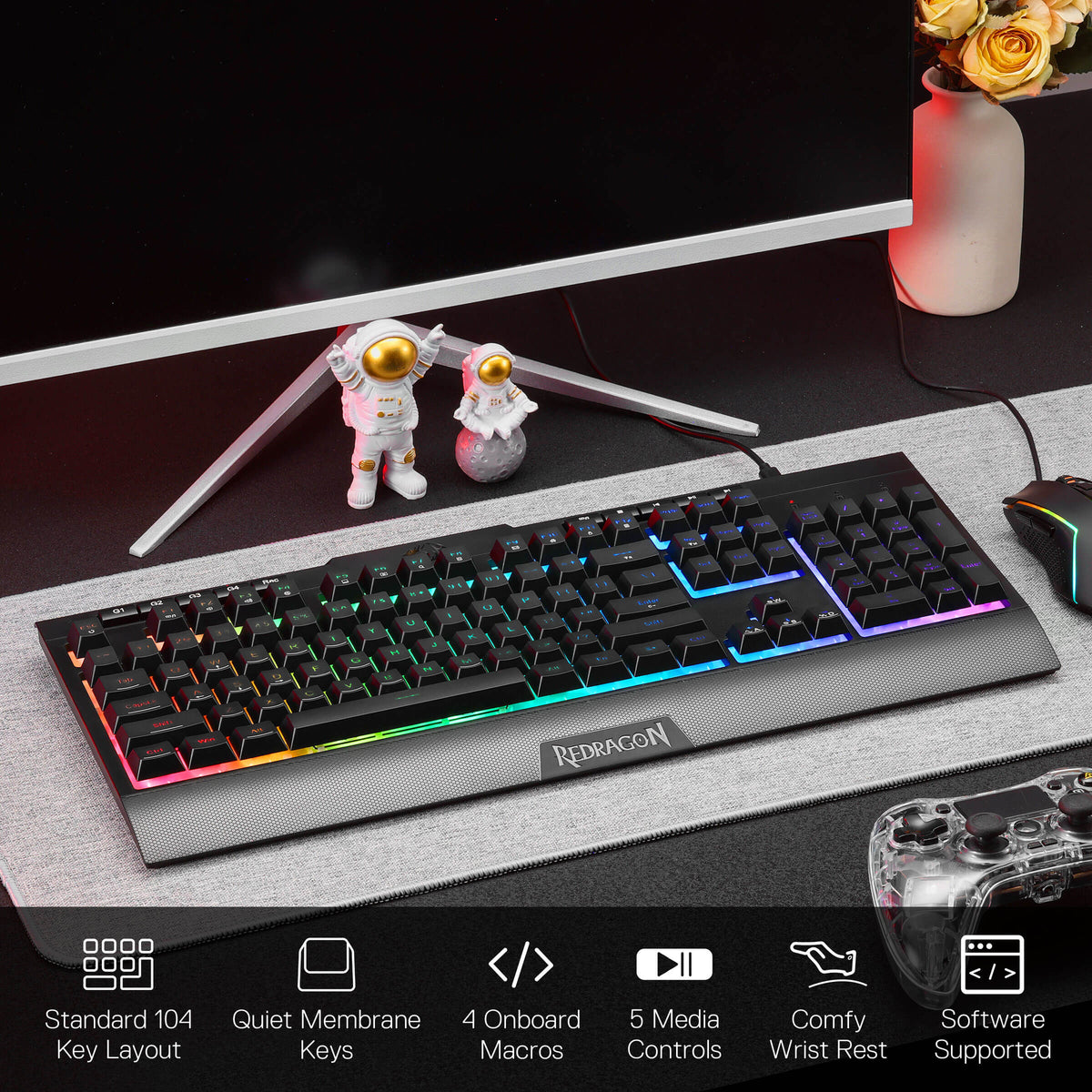 Redragon EU S151 Gaming keyboard on a desk with monitor, figurines, and decorative elements.
