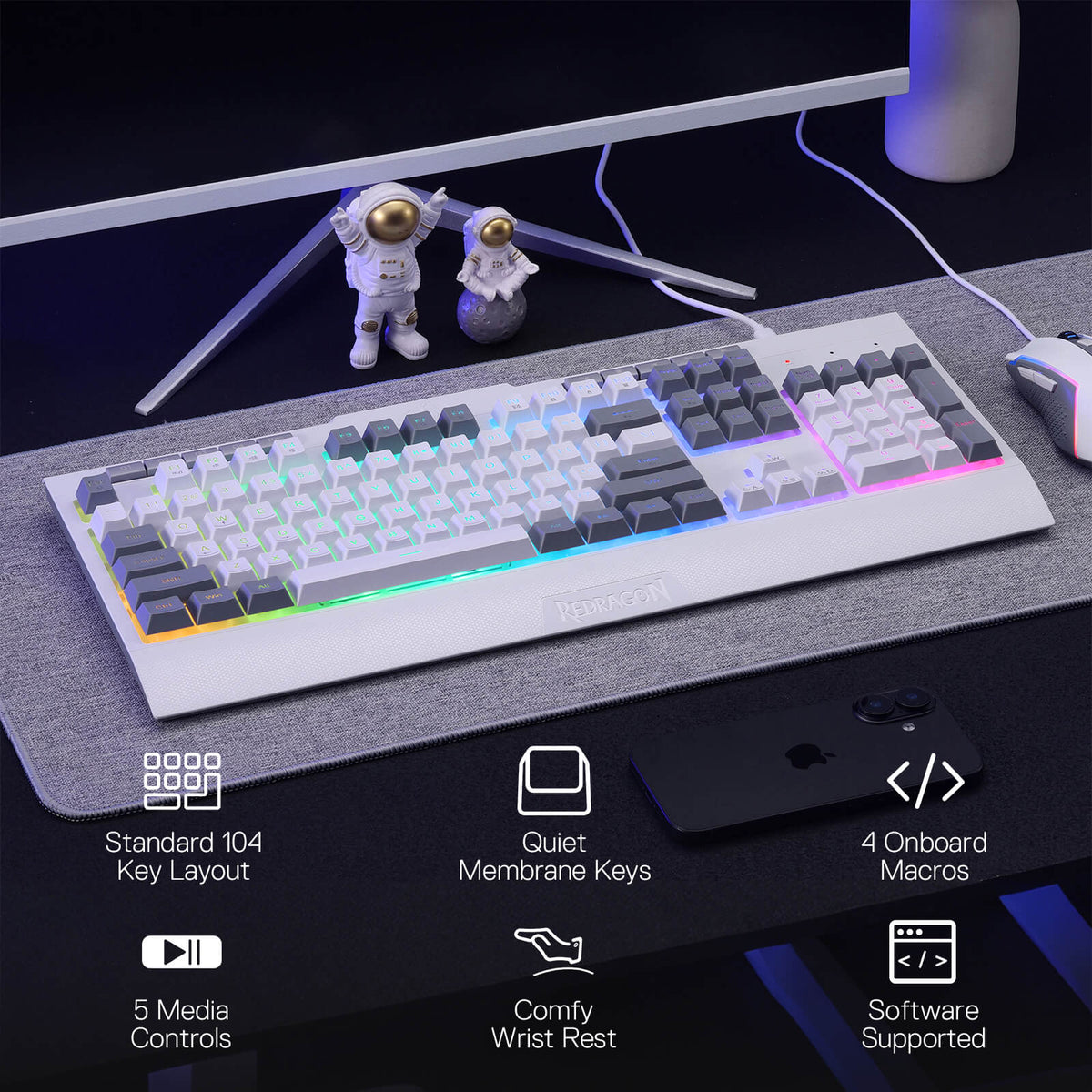 Mechanical keyboard on a desk with astronaut figurines and computer monitor