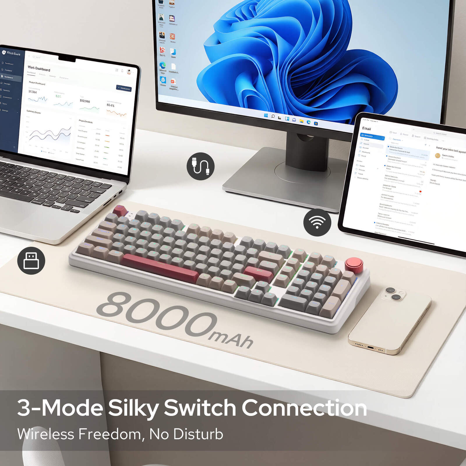 Desk setup with a keyboard, laptop, and monitor displaying software interfaces.